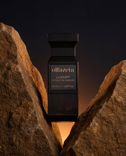 Černý flakon Olfazeta by Chogan Luxury N°74 stojící mezi dvěma okrovými skalami při západu slunce